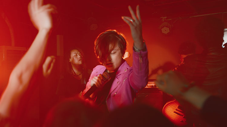 a young woman singing into a microphone in a packed night club