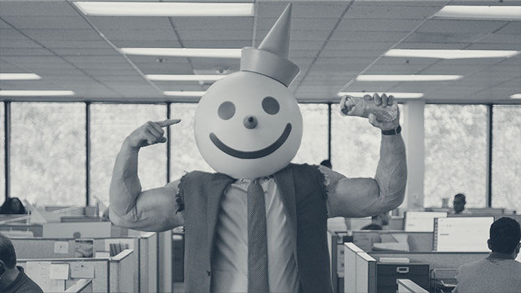 a man in a suit and tie with the sleeves ripped off flexing his large biceps and wearing a cartoonish clown head