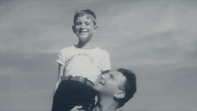 a dated photograph of a father holding his small son up on his shoulder